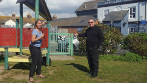 Cllr Clare Sutton receives a donation for the Chapelhay Community Playgarden from Father Andrew Gough