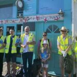 A group of about ten litter pickers in high viz jackets standing in front of Bennett's fish and chip shop