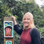 Claudia smiling next to a sign on the Rodwell Trail