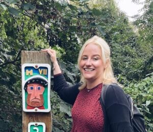 Claudia smiling next to a sign on the Rodwell Trail